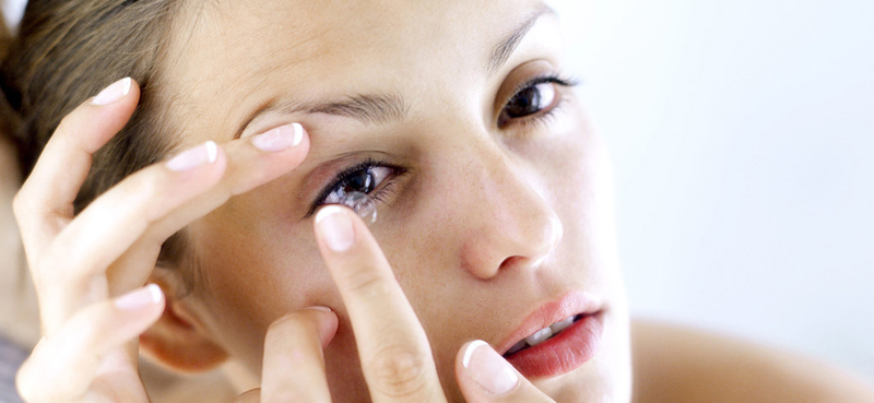 Woman putting her contacts into the eye